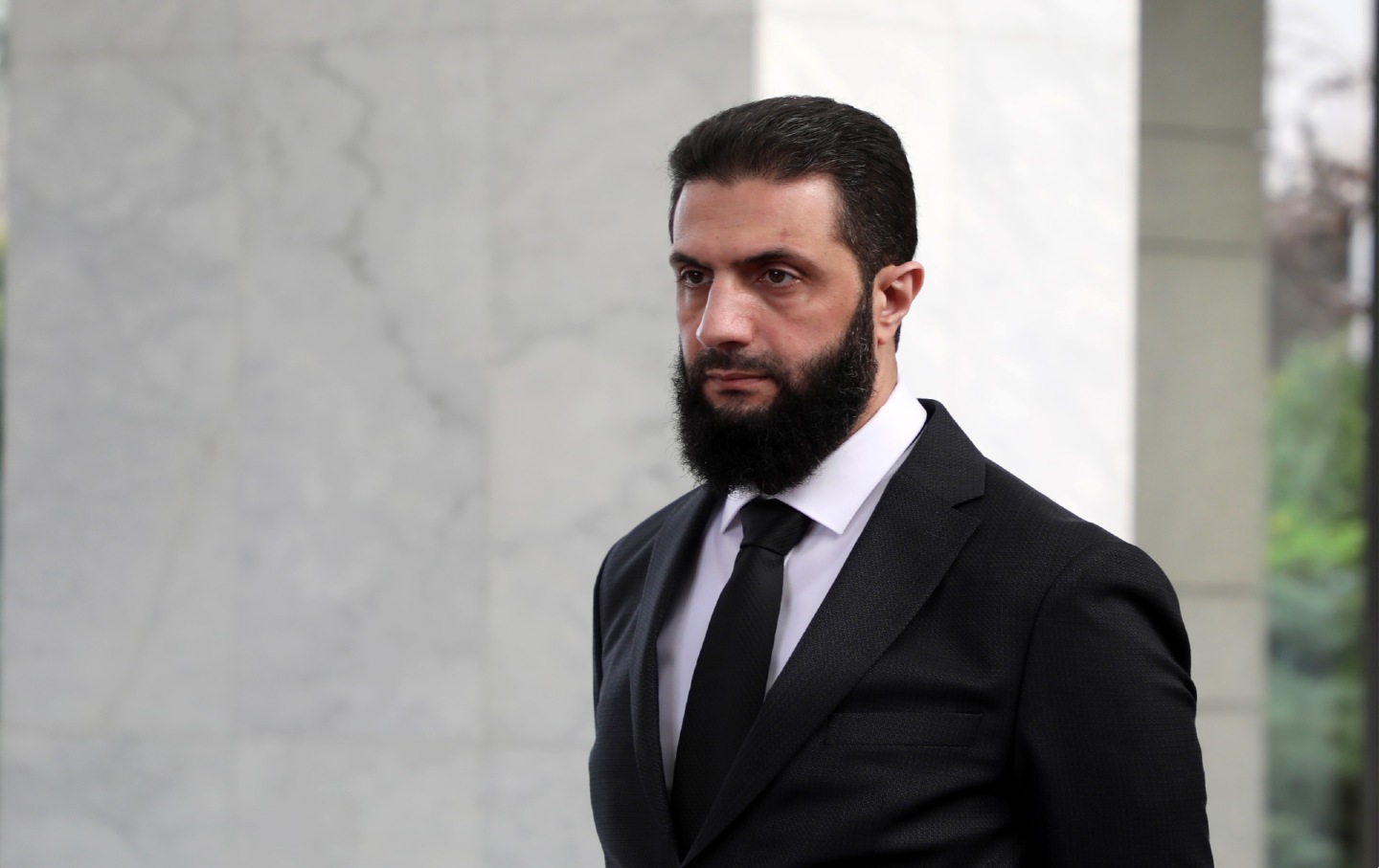 The leader of the new Syrian administration, Ahmed al-Shara, waits to greet a Ukrainian delegation ahead of a meeting to help strengthen ties between the two countries in December 2024 in Damascus, Syria.