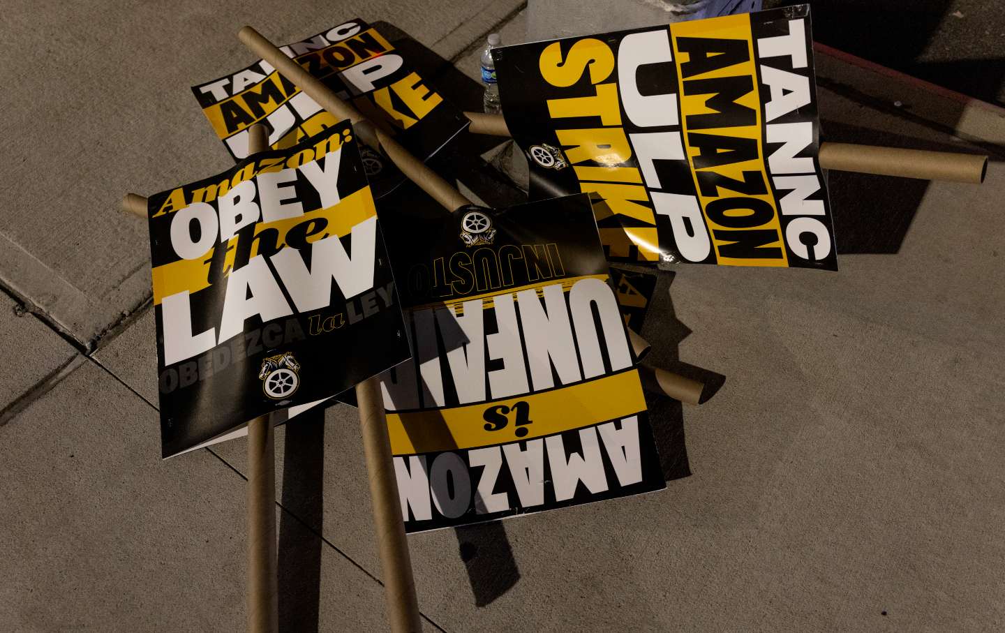 Picket signs lie on the ground as Amazon workers organized by the Teamsters Union go on strike in front of the DBK4 Amazon facility on December 20, 2024.