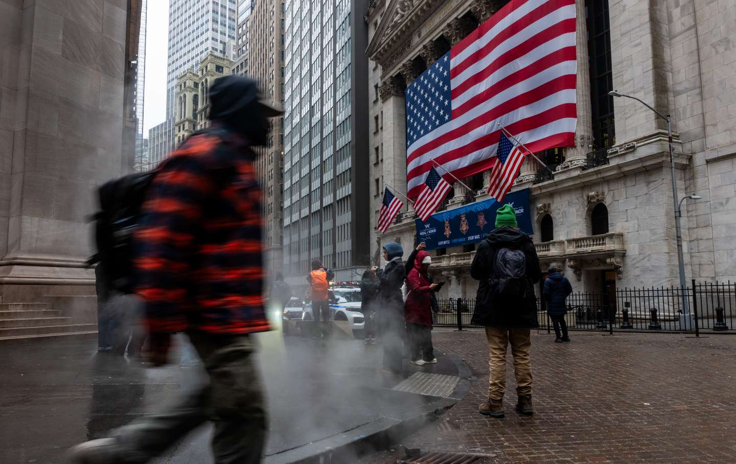 People walk by the New York Stock Exchange as the Dow plunges 700 points in response to the US-Israel war against Iran, on March 5, 2026.