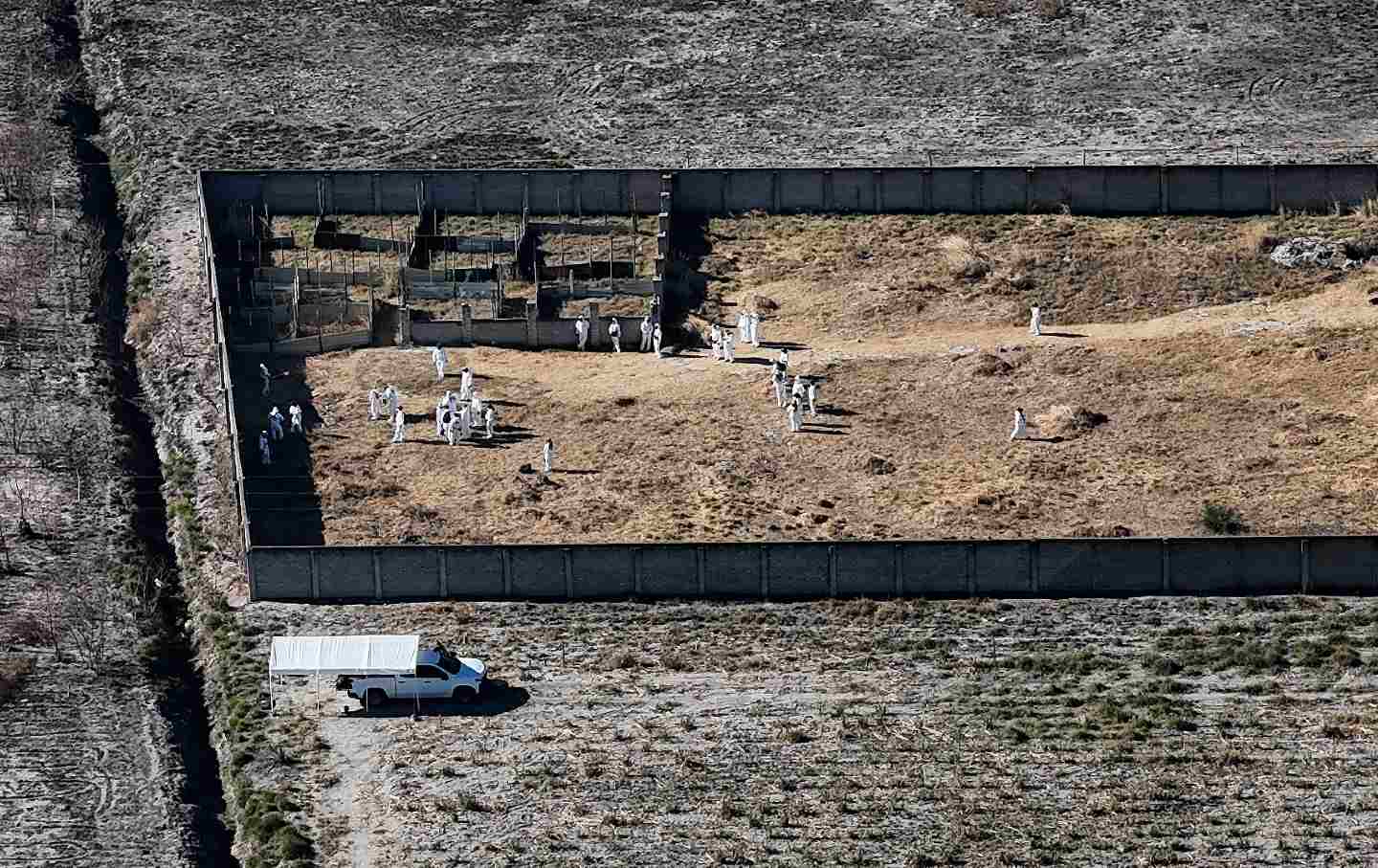 This aerial picture shows white-clad forensic experts from the Mexican Attorney General’s Office walking inside the alleged organized crime “extermination camp” in the municipality of Tehuchitlan, Jalisco, Mexico, on March 28, 2025.