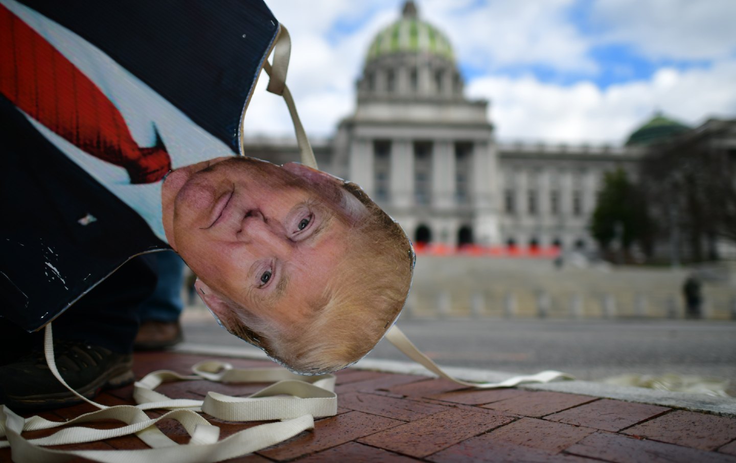 An effigy of President Donald Trump is lowered outside the Pennsylvania State Capitol.