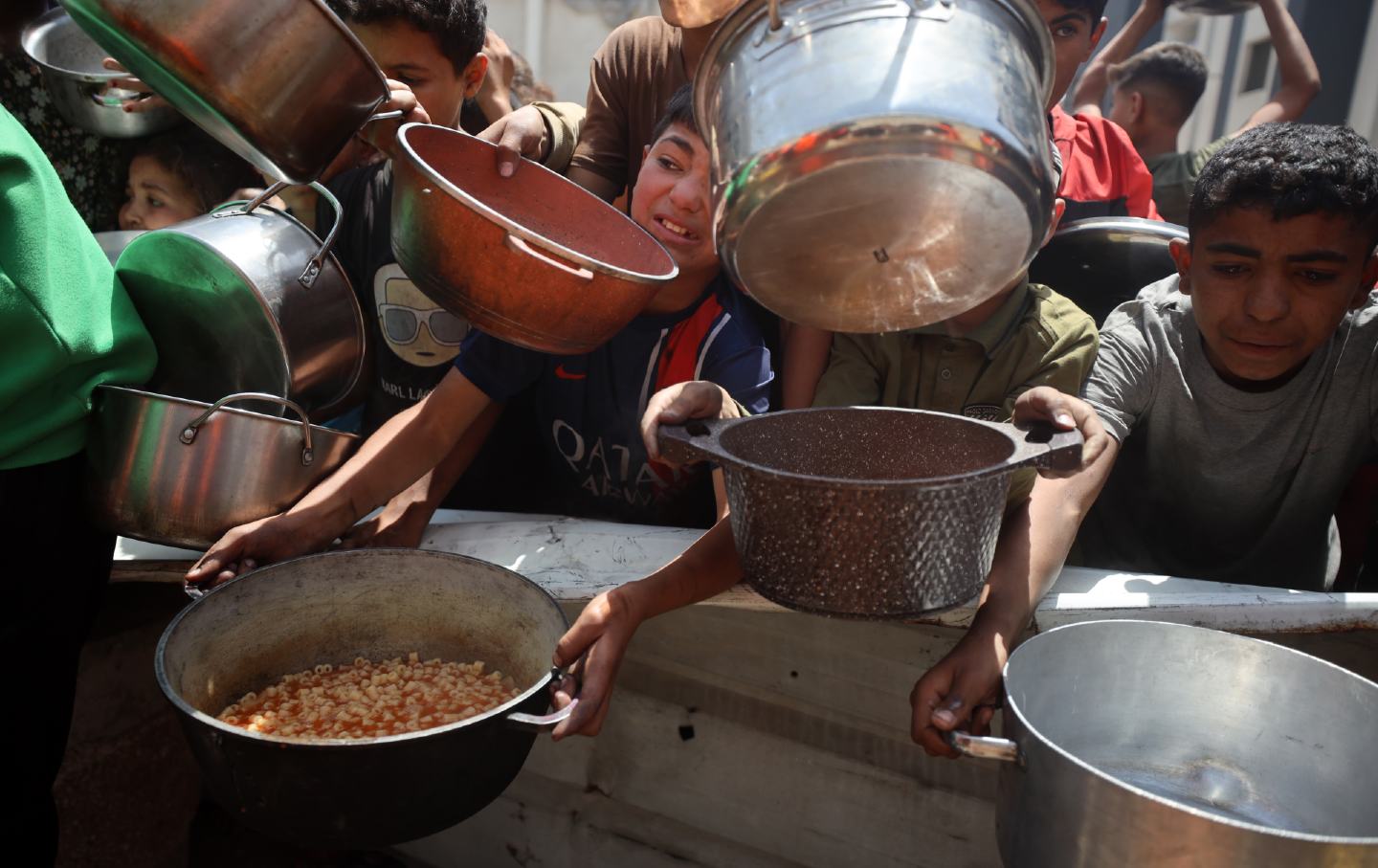 Children line up for a hot meal at a charity kitchen in Gaza City, on May 3, 2025.