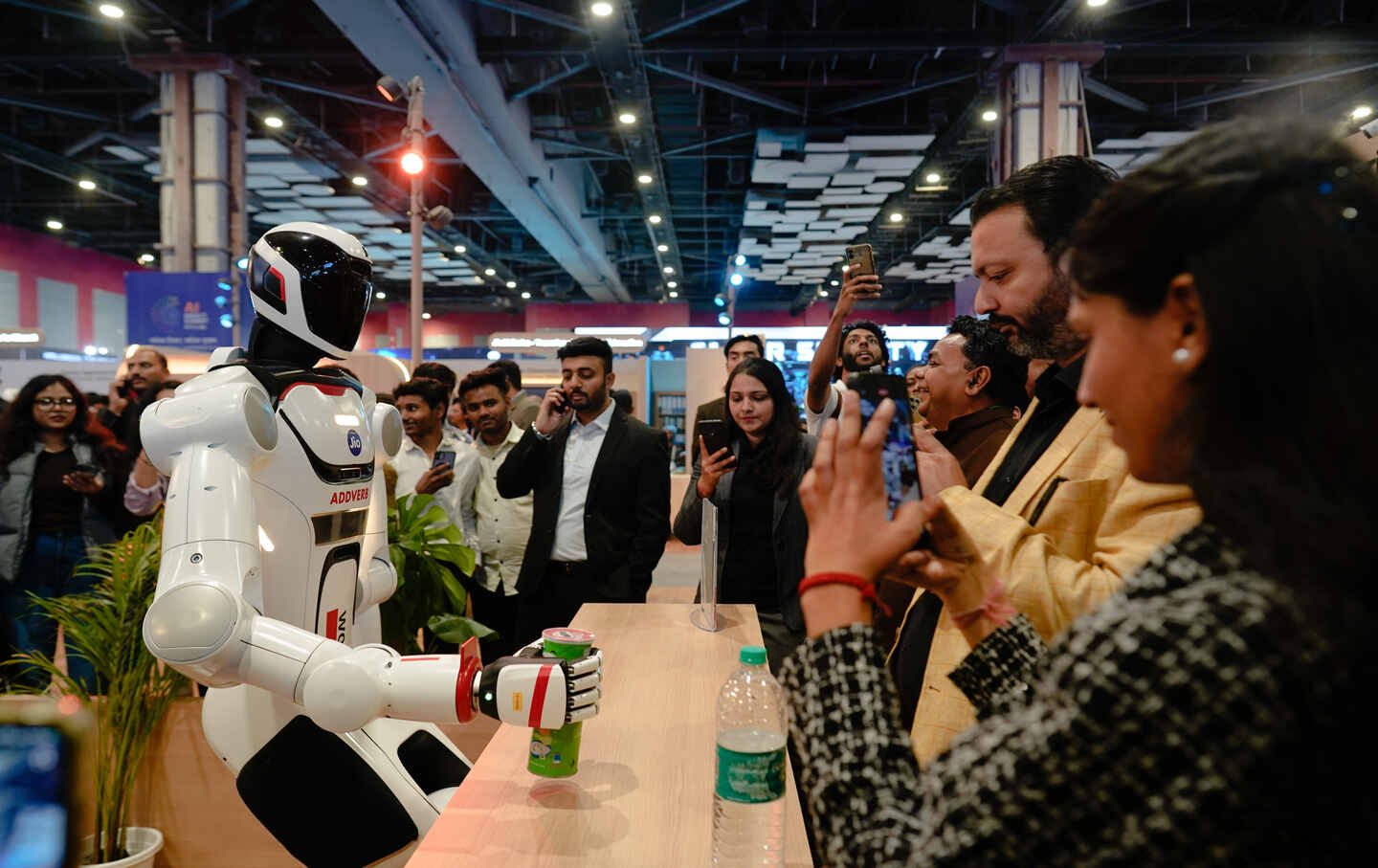 Attendees interact with Elixis-W, a humanoid robot made by Addverb Technologies, at the AI Impact Summit in New Delhi, India, on February 20, 2026.