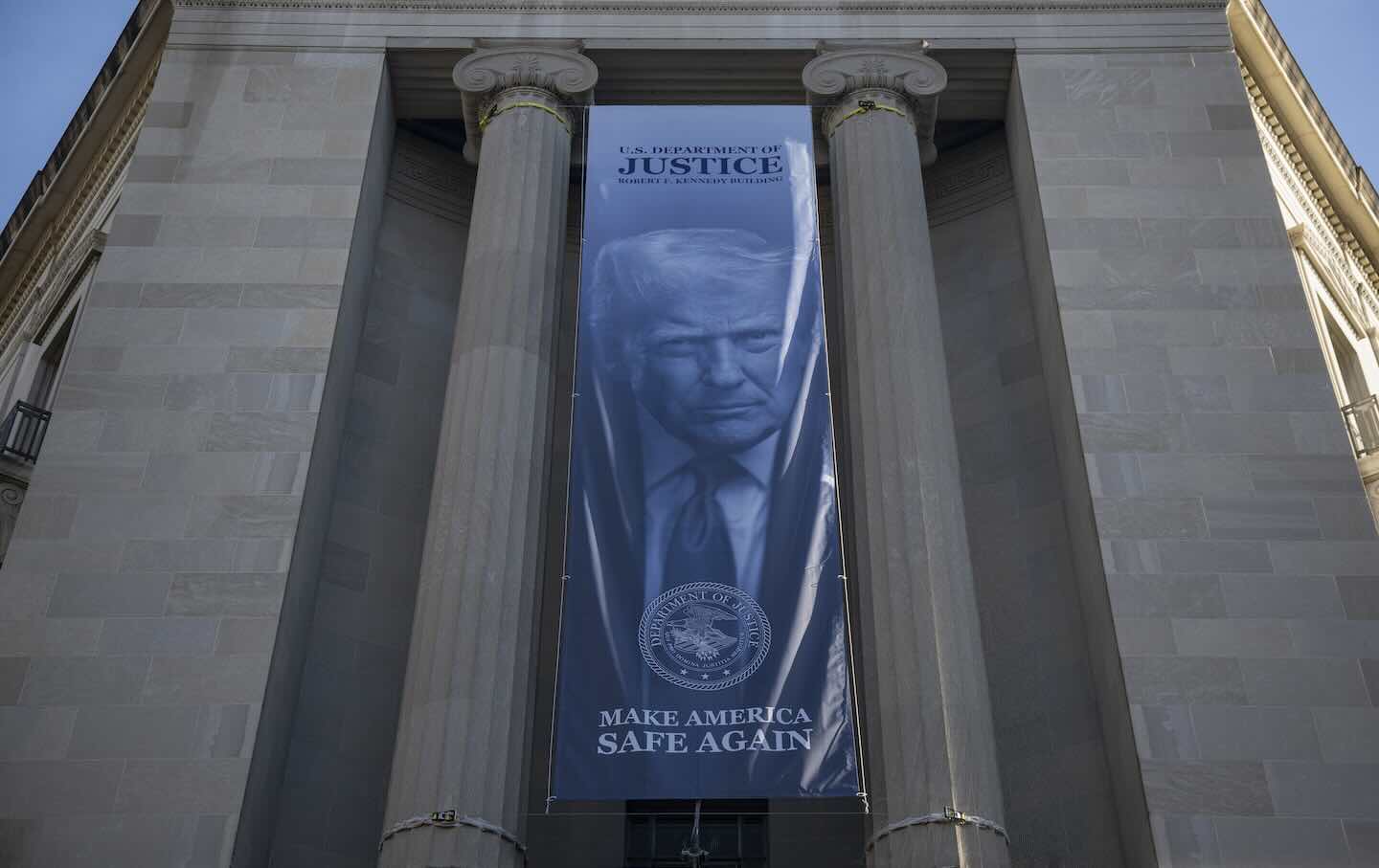 A banner featuring an image of US President Donald Trump with the slogan “Make America Safe Again” is displayed on the facade of the US Department of Justice headquarters in Washington, DC, on February 20.