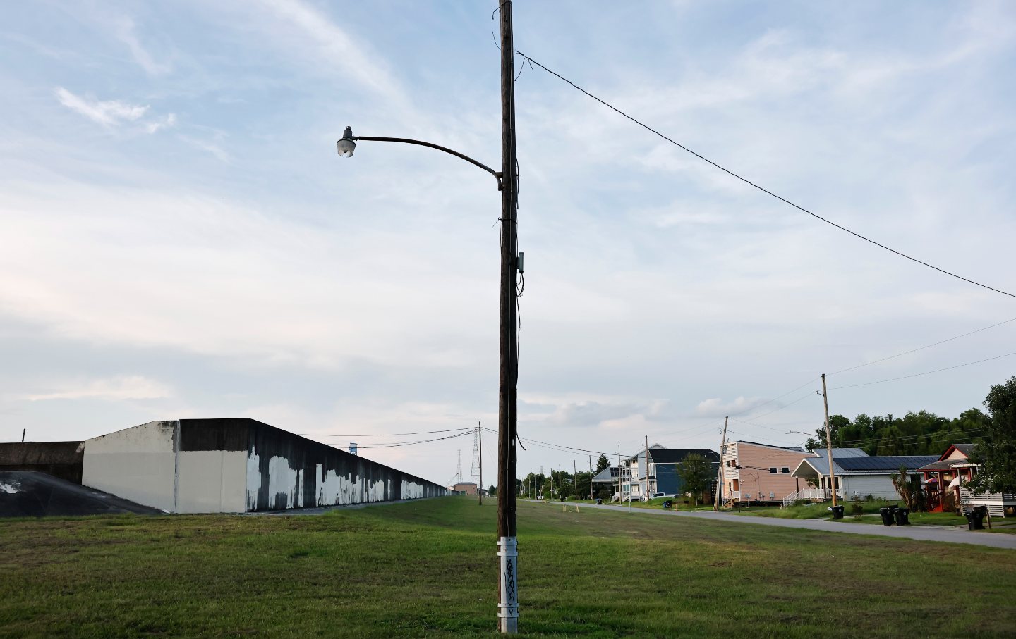 The rebuilt Industrial Canal levee wall (L) in the Lower Ninth Ward stands near restored homes in New Orleans, Louisiana, on August 6, 2025.