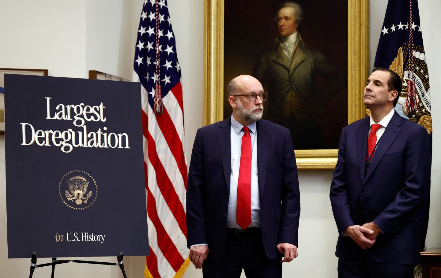 Russell Vought (left), architect of the Mandate for Leadership, more commonly known as Project 2025, and director of the Office of Management and Budget (OMB), stands alongside Mark Paoletta (right), general counsel at the OMB, during the Trump administration's announcement of the rescission of the Obama-era endangerment finding in the Roosevelt Room of the White House in Washington, DC, on February 12, 2026.