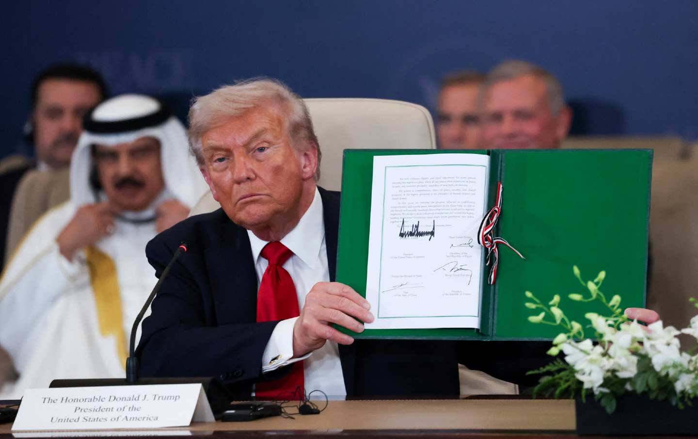 President Donald Trump displays the Gaza agreement endorsed by regional leaders at Sharm El-Sheikh, Egypt.