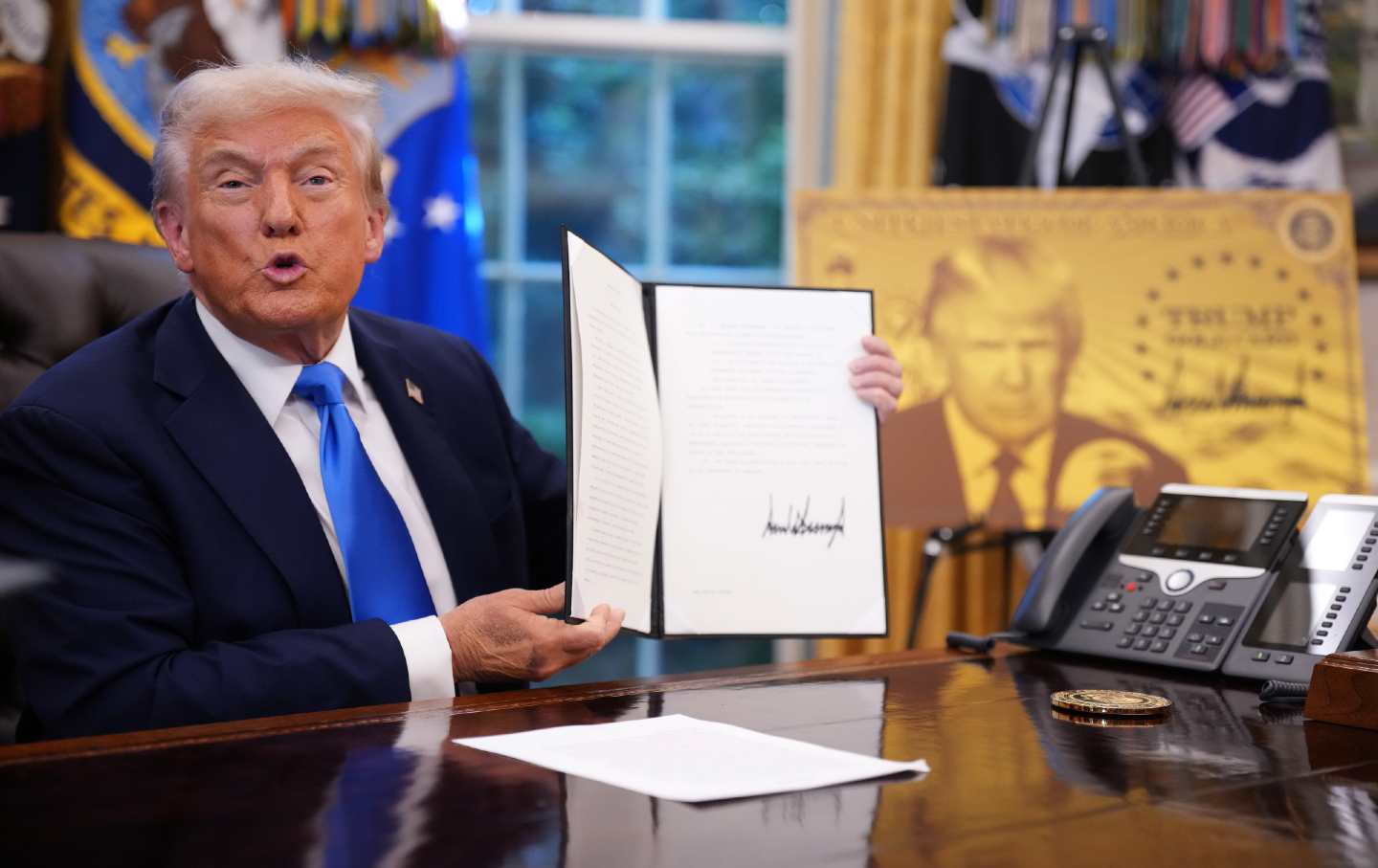 President Donald Trump displays his executive order establishing the Trump Card for HB-1 visa applicants at the Oval Office on September 19.