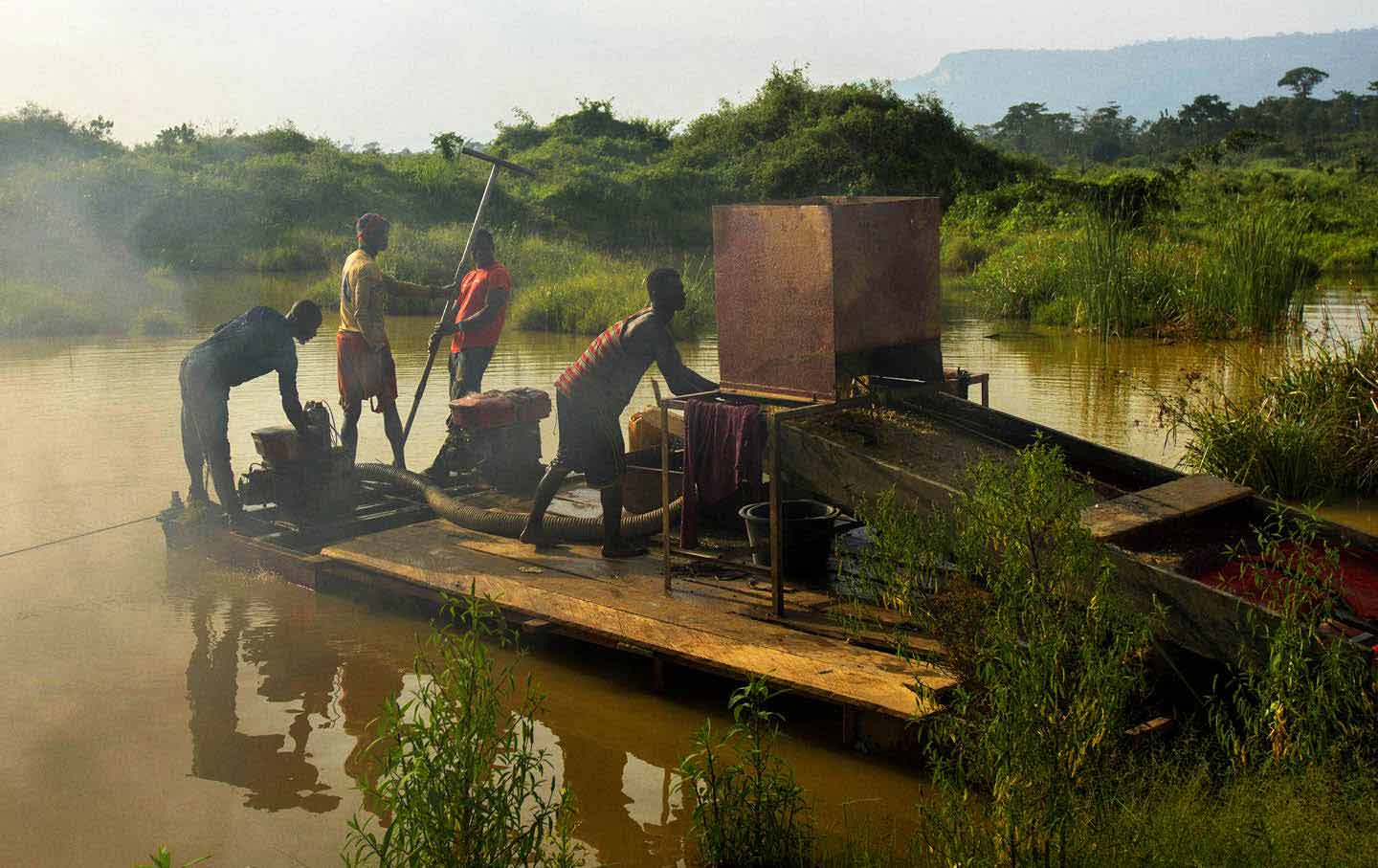 A group of men engaged in illegal gold mining look for specks of gold in Kibi in southern Ghana.